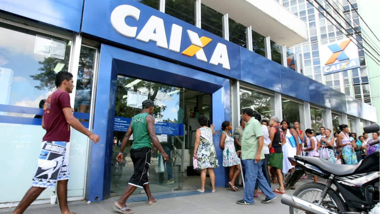 Imagem pessoas entrando em uma agência da Caixa