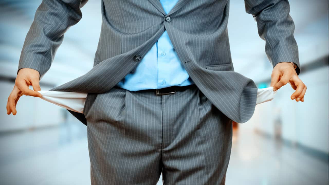 Homem tirando os bolsos vazios do terno
