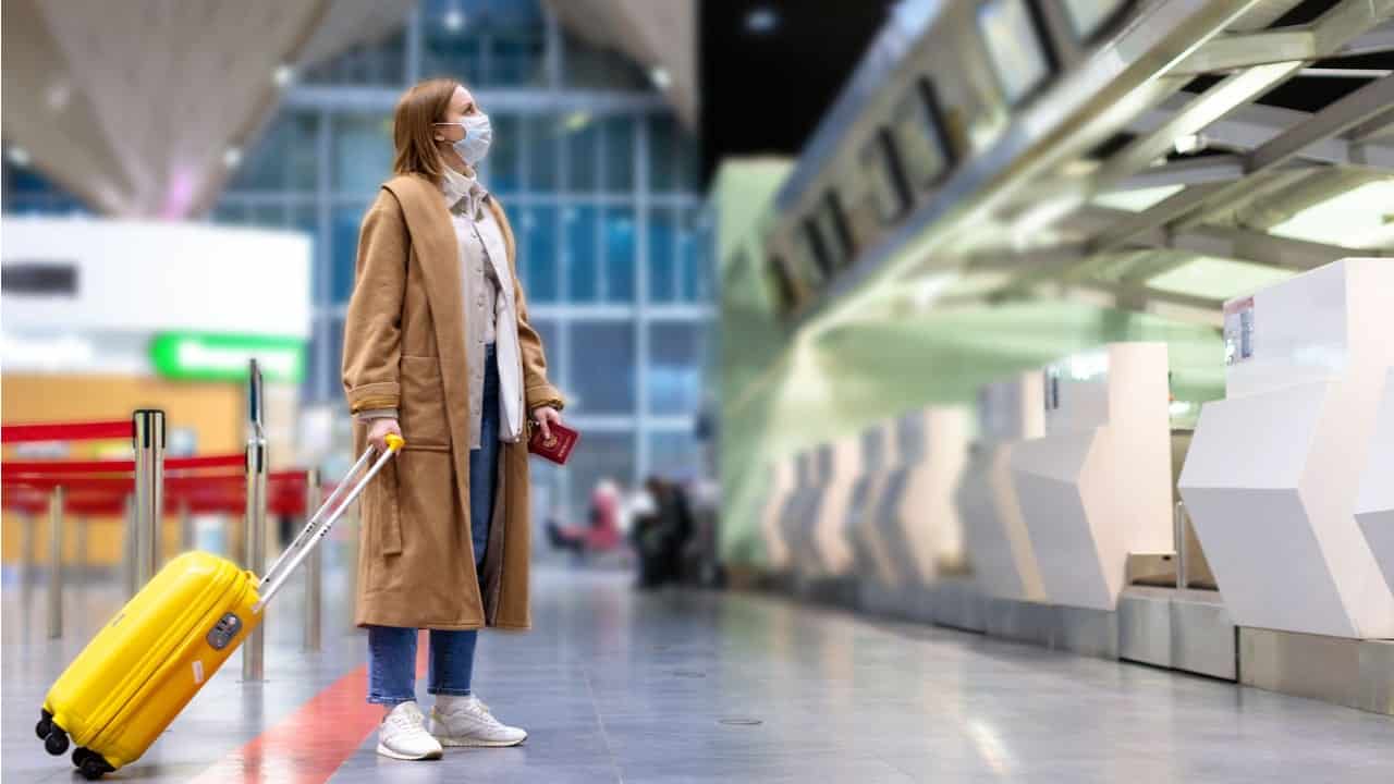 Mulher em aeroporto olhando os horários de voos