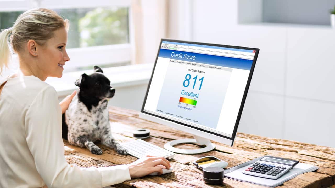 Mulher em frente a um computador com score da serasa no valor de 811