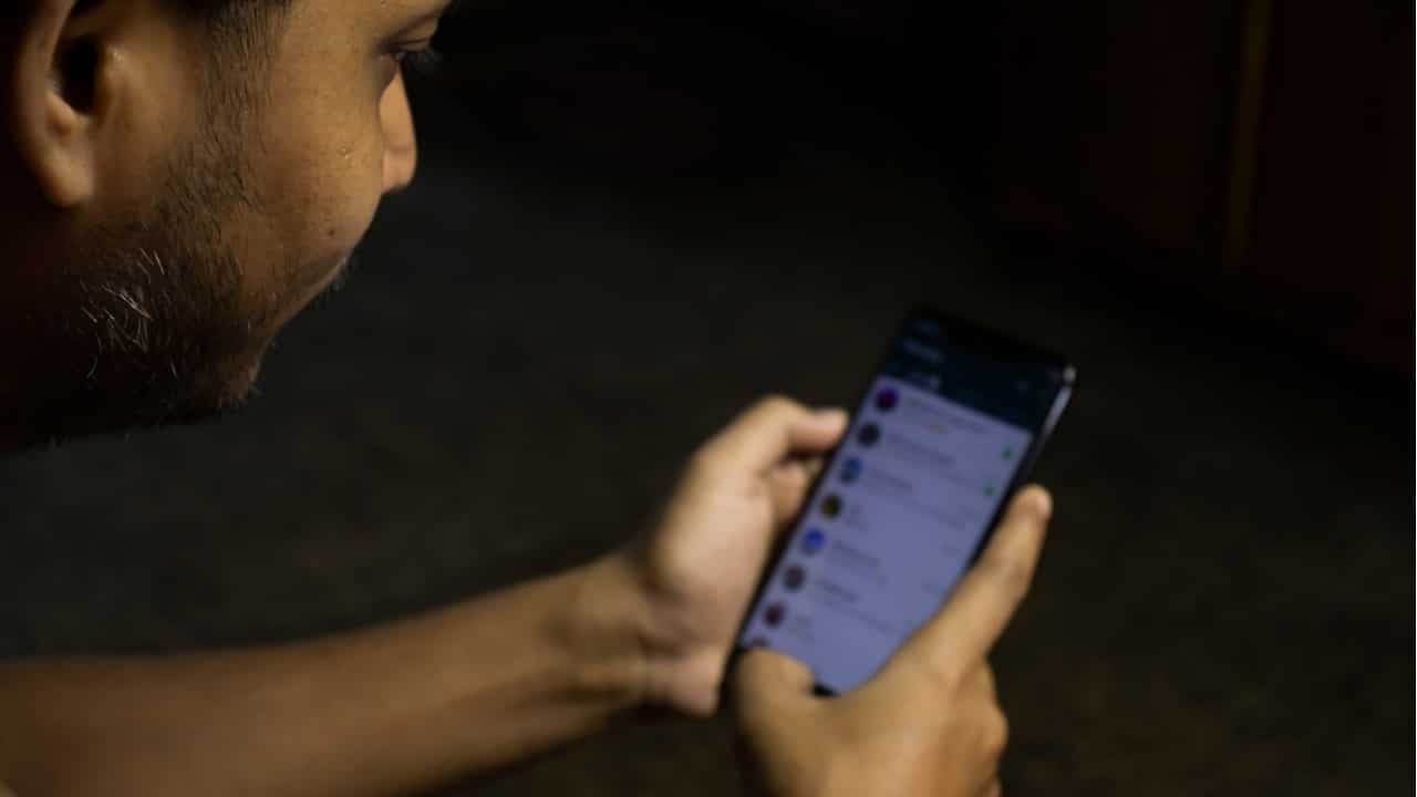 Imagem de um homem usando o aplicativo do WhatsApp em seu celular