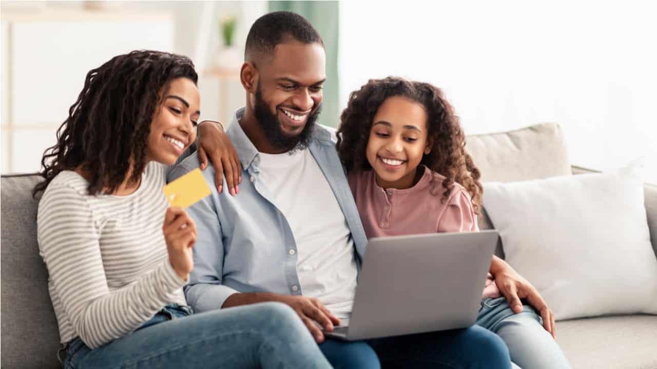Família contente de frente a um notebook