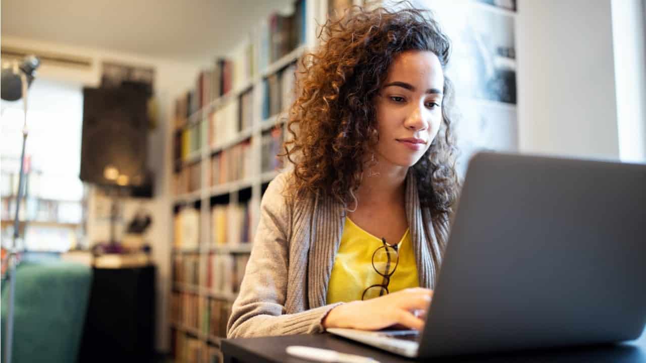 Imagem jovem trabalhando enquanto digita em um notebook