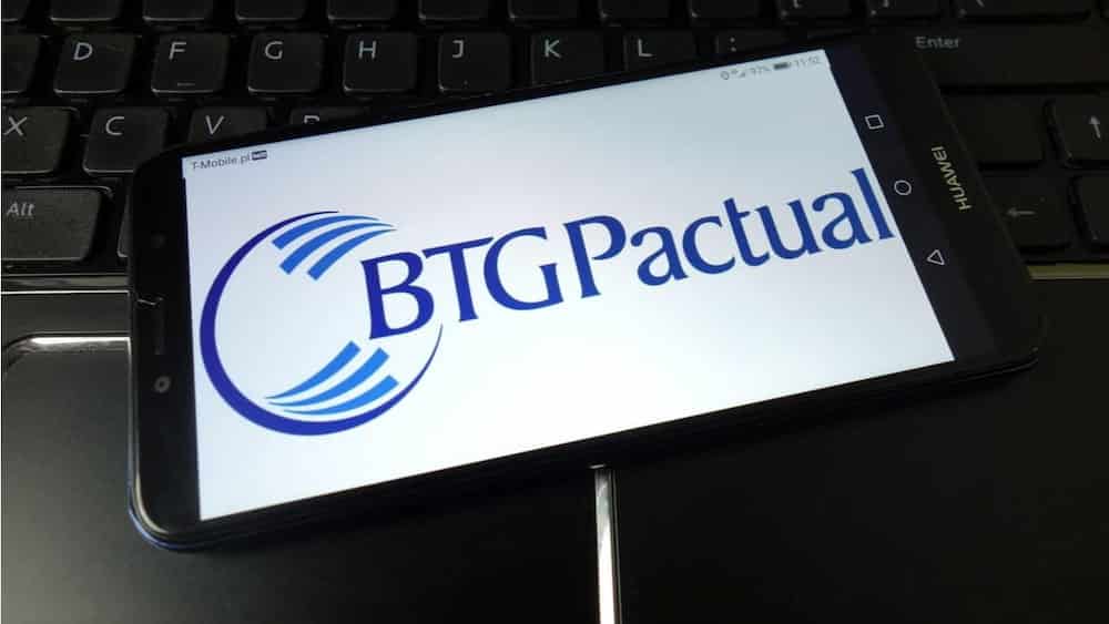 Imagem da logo do BTG Pactual em um celular sobre um teclado