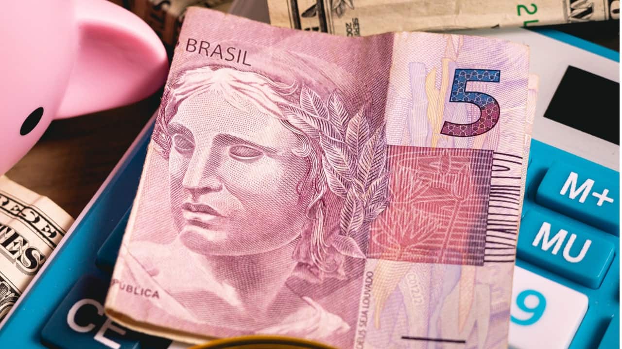 Nota de R$ 5 dobrada sobre uma calculadora