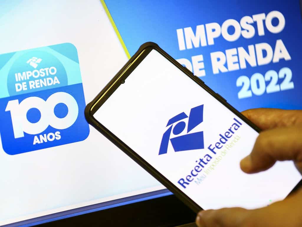 Mão segurando celular com aplicativo da Receita Federal