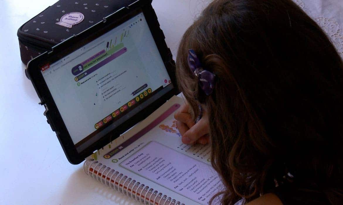 Criança estudando por meio de um computador