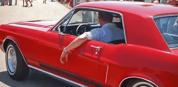 Motorista com o braço apoiado na janela.