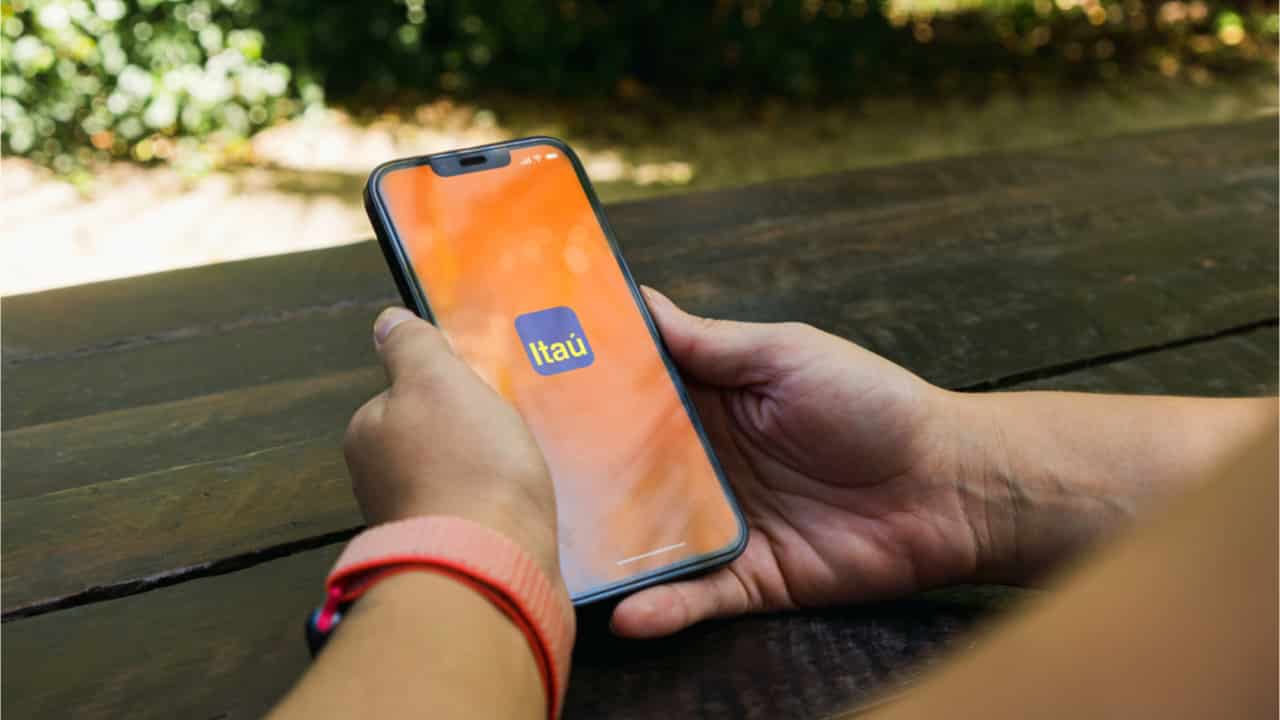 Pessoa mexendo no celular que tem o aplicativo do Itaú aberto