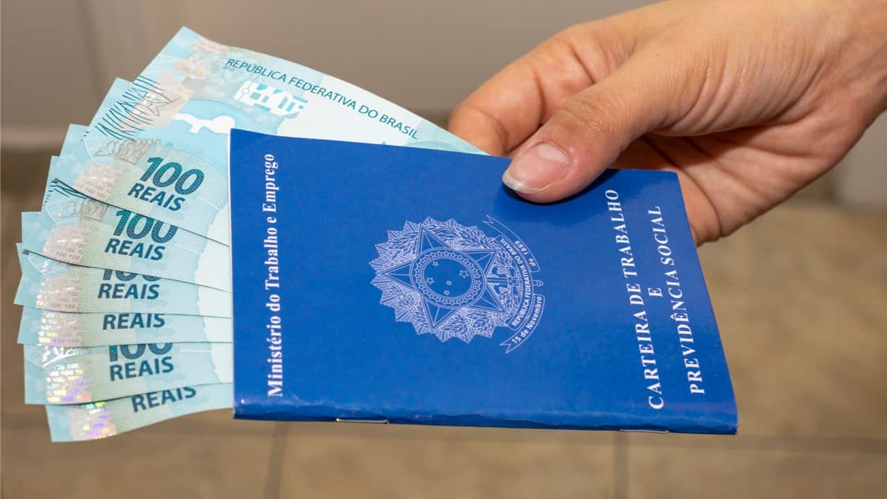 imagem de várias notas de dinheiro dentro de carteira de trabalho
