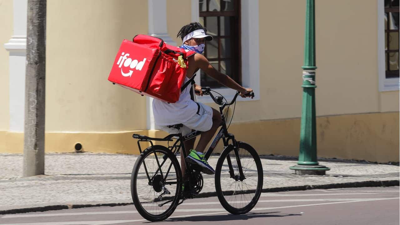 Trabalhador informal de rede de entrega de comida em uma bicicleta