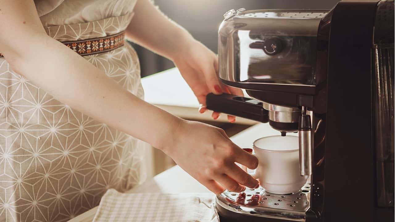 Imagem de pessoa preparando café em um cafeteira
