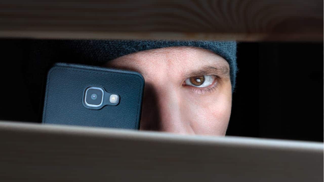 Pessoa escondida fazendo gravação com celular