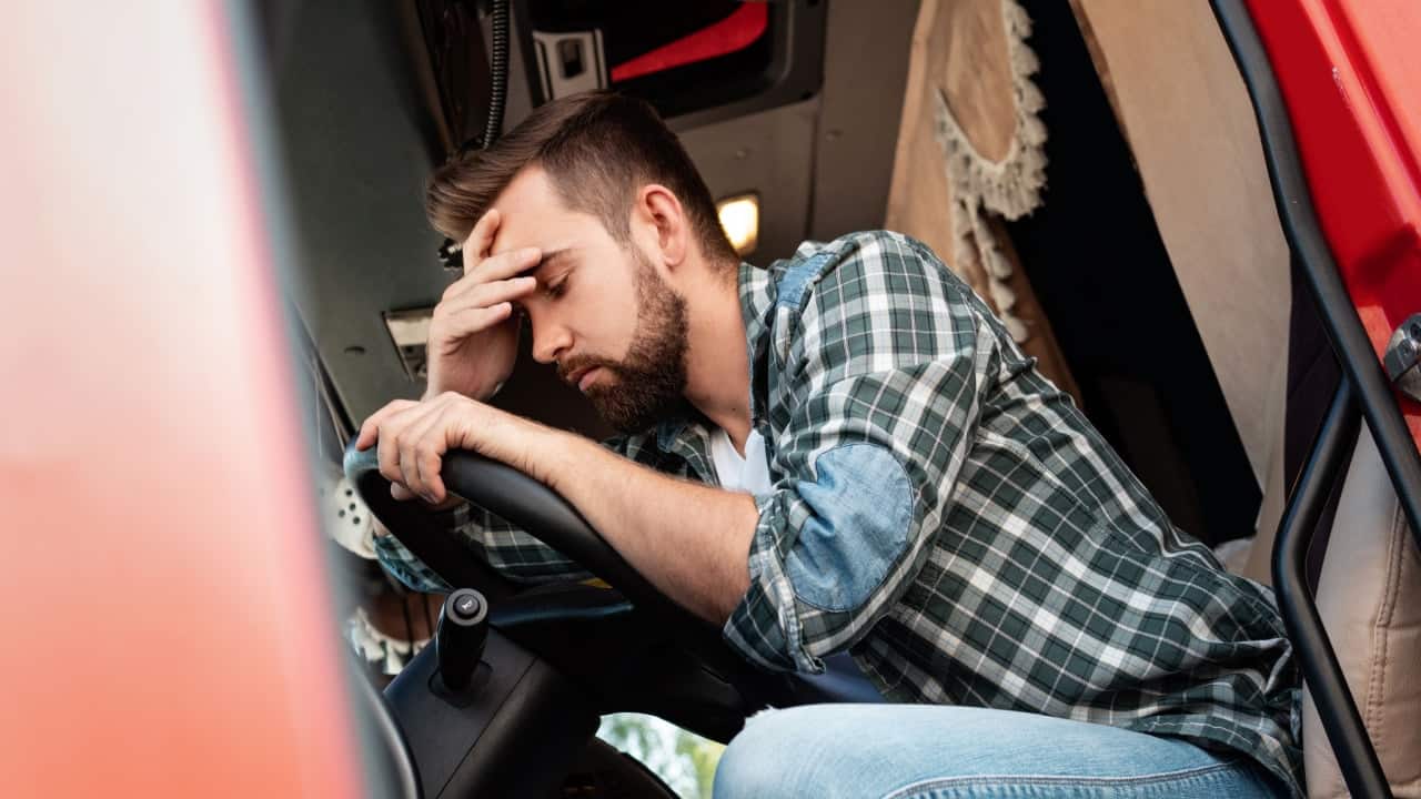 Homem em seu carro com feição de preocupado