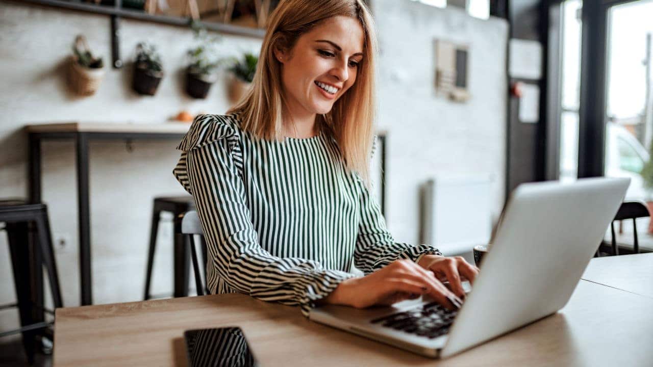 Mulher feliz em frente ao computador