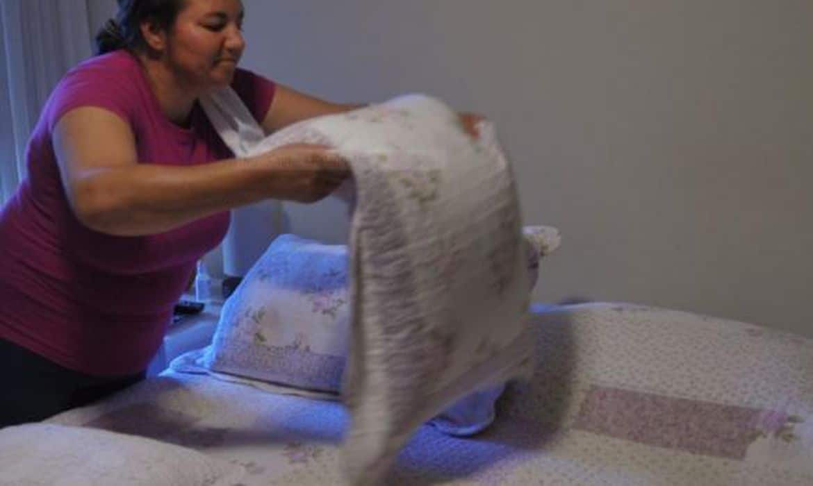 Mulher arrumando a cama