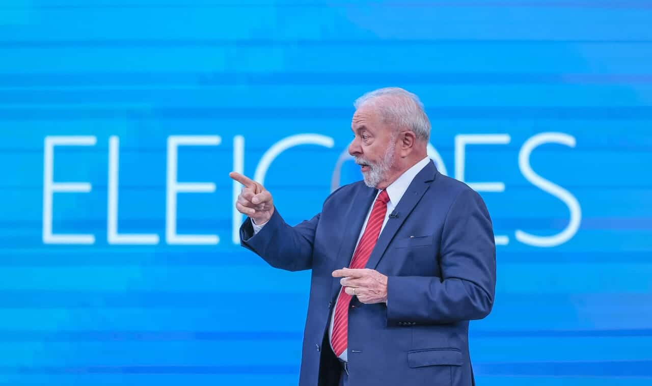 Imagem de Lula, presidente eleito, durante debate eleitoral de 2022 apontando o indicador da mão direita.