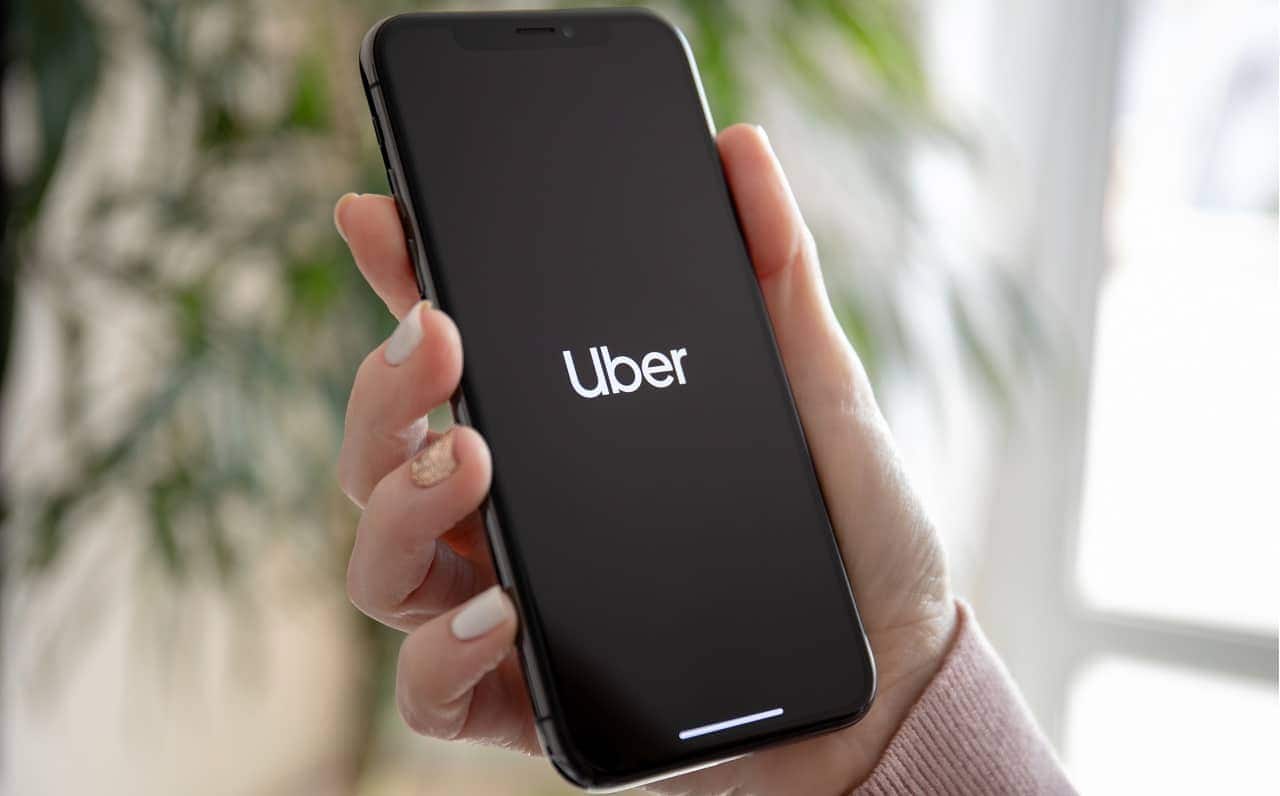 Mão segurando celular com aplicativo da Uber