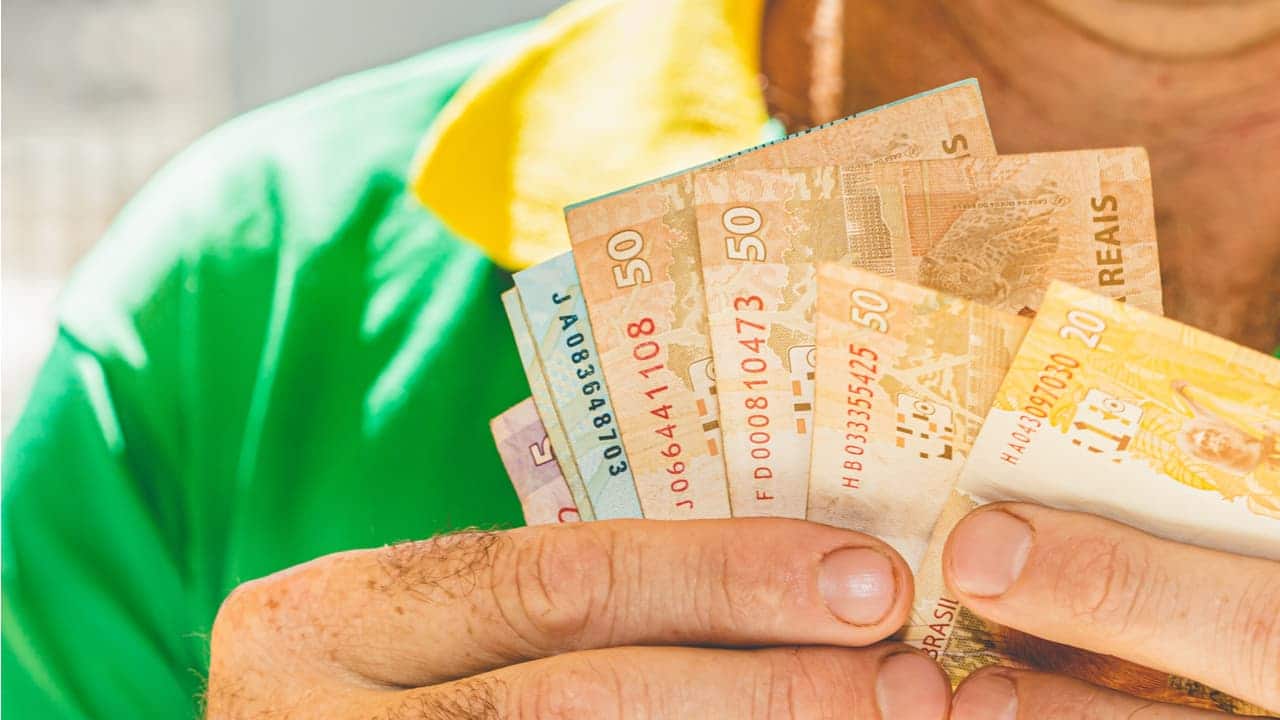 Mão segurando notas de dinheiro