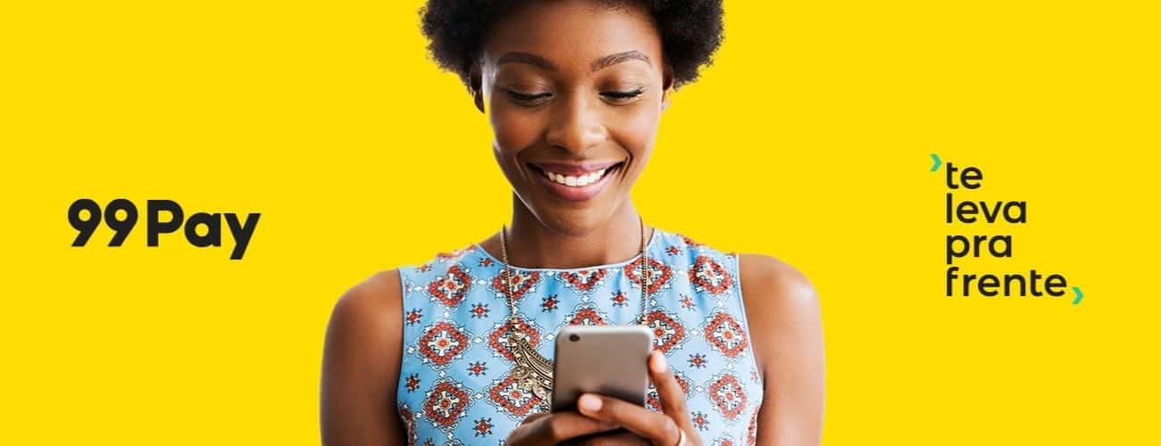 Divulgação da carteira digital 99Pay mostra mulher sorrindo para tela do celular