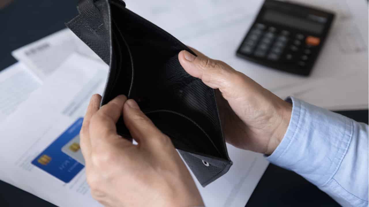 Imagem de uma pessoa olhando para sua carteira de dinheiro vazia