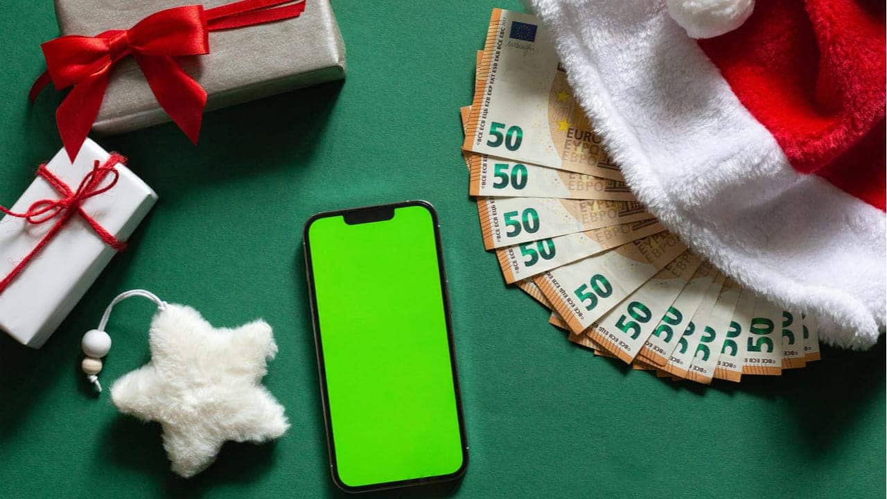 Imagem de um celular com cédulas ao lado