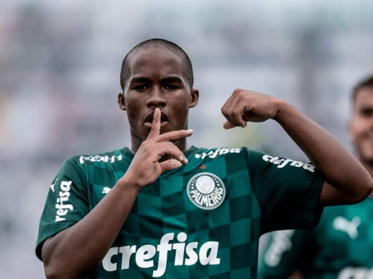 Foto do jogador Endrick fazendo sinal de silêncio com a mão na boca