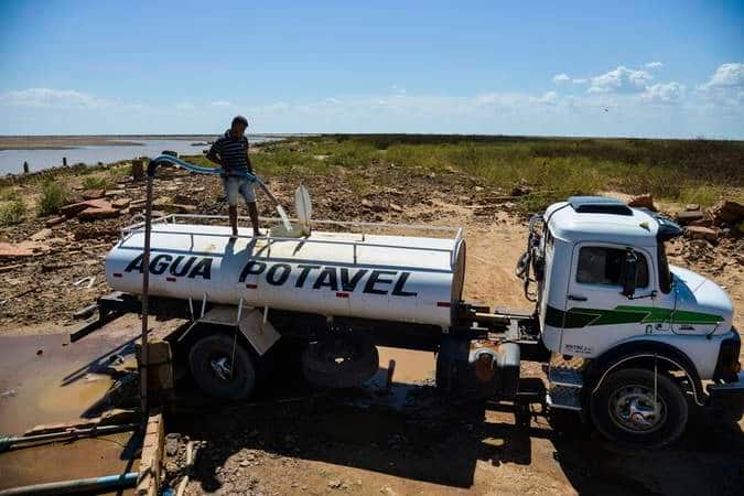 Caminhão pipa de água potável abastecendo cisterna