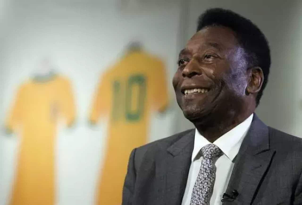 Pelé sorrindo com camisa 10 da seleção brasileira ao fundo