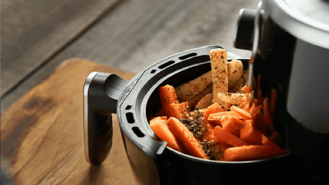 Imagem de uma airfryer com legumes dentro