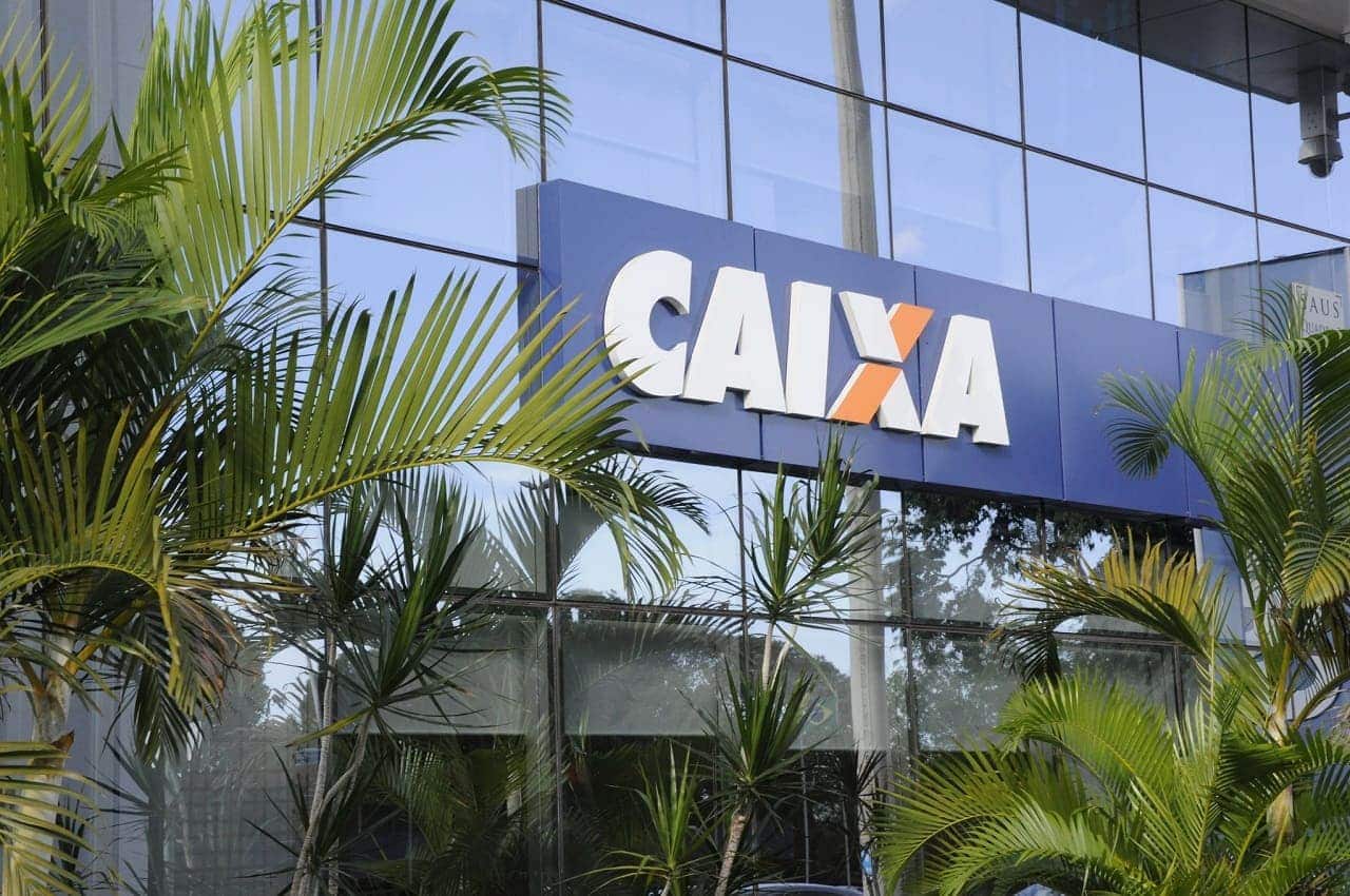 Imagem de uma agência da Caixa, com plantas na entrada