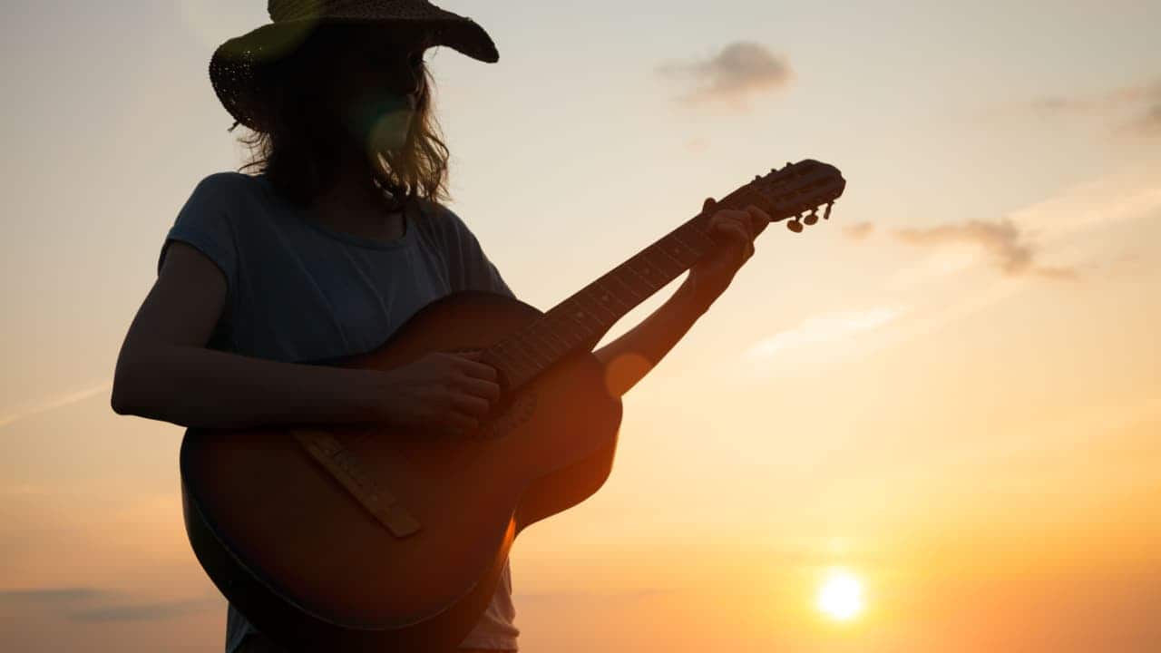 imagem de uma cantora sertaneja tocando violão