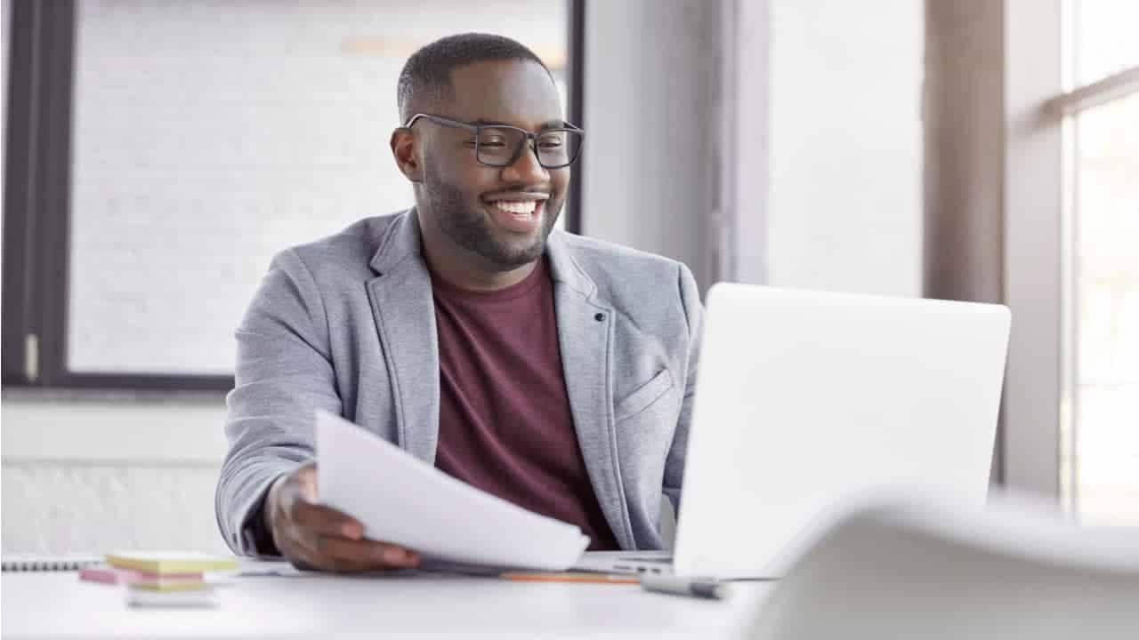 Um homem sentado a mesa com um notebook