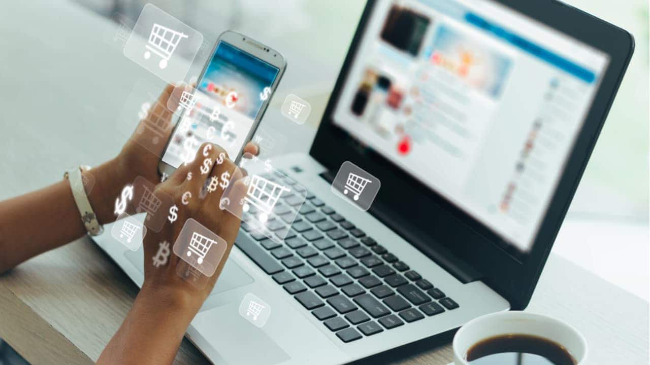 Mão segurando celular com tela mostrando compras online