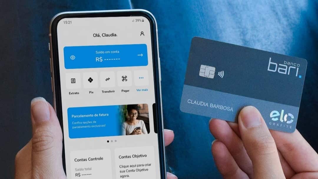 Mãos segurando celular que mostra aplicativo do Banco Bari e cartão do banco