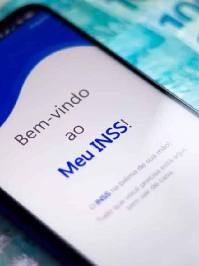 Celular com aplicativo Meu INSS sobre notas de 100 reais