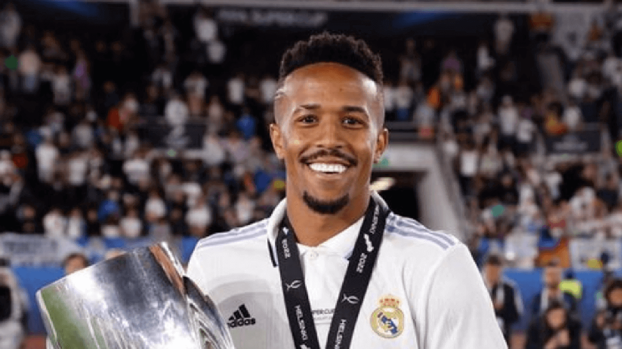 Jogador brasileiro Éder Militão posado segurando uma taça que ganhou em campeonato