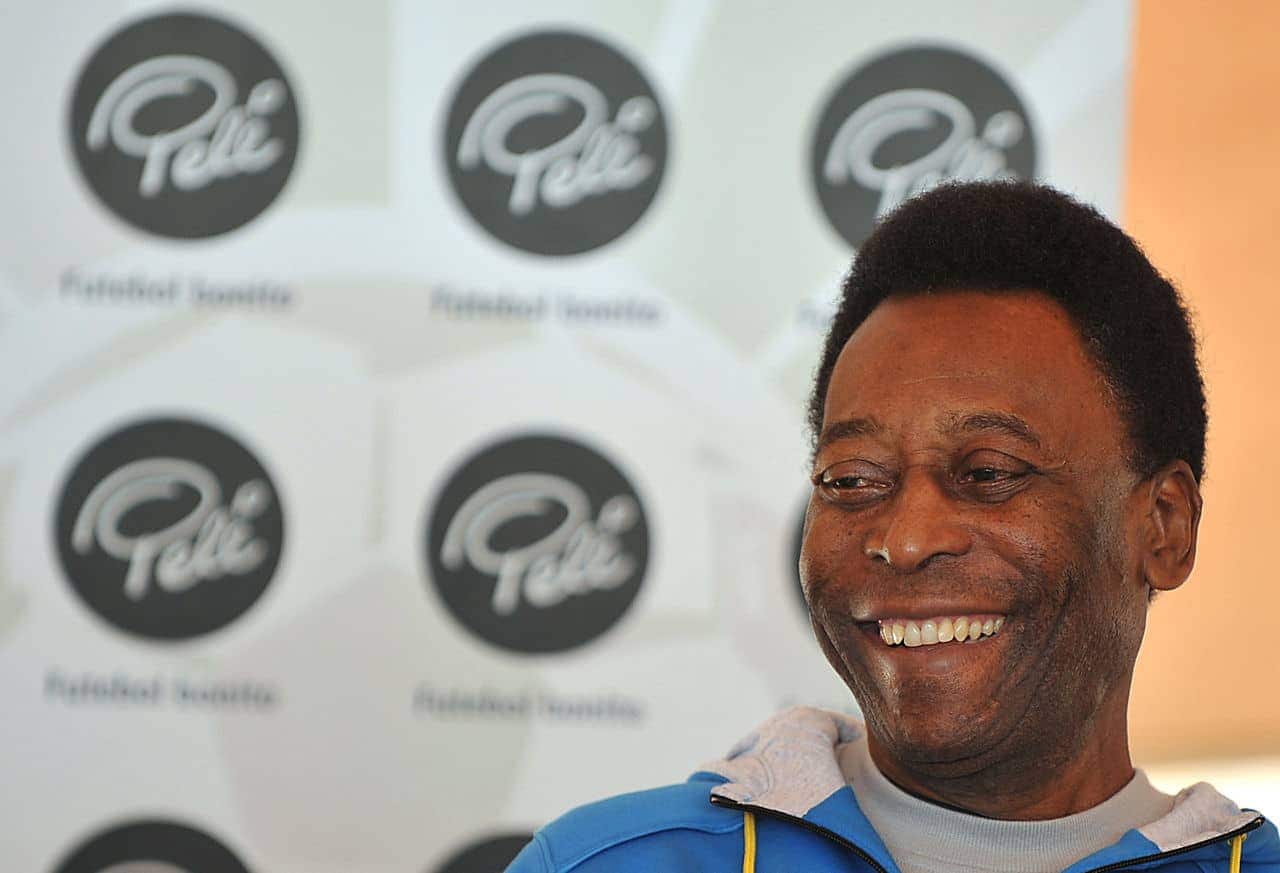 Imagem que Pelé, sentado, aparece sorrindo.