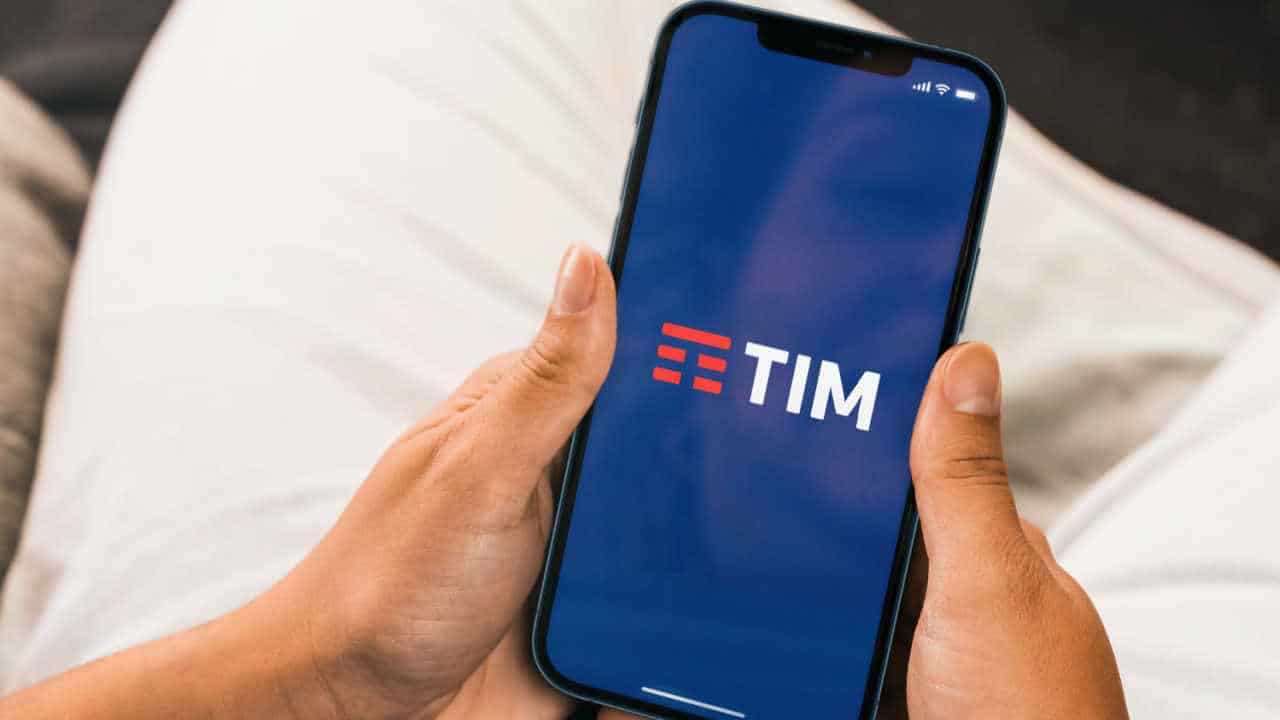 Mão feminina segurando celular com tela mostrando o aplicativo Tim
