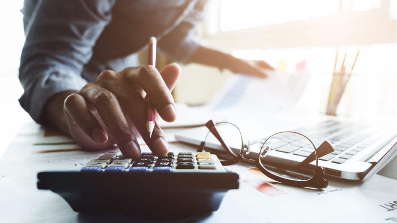 empresário fazendo contabilidade enquanto usa a calculadora