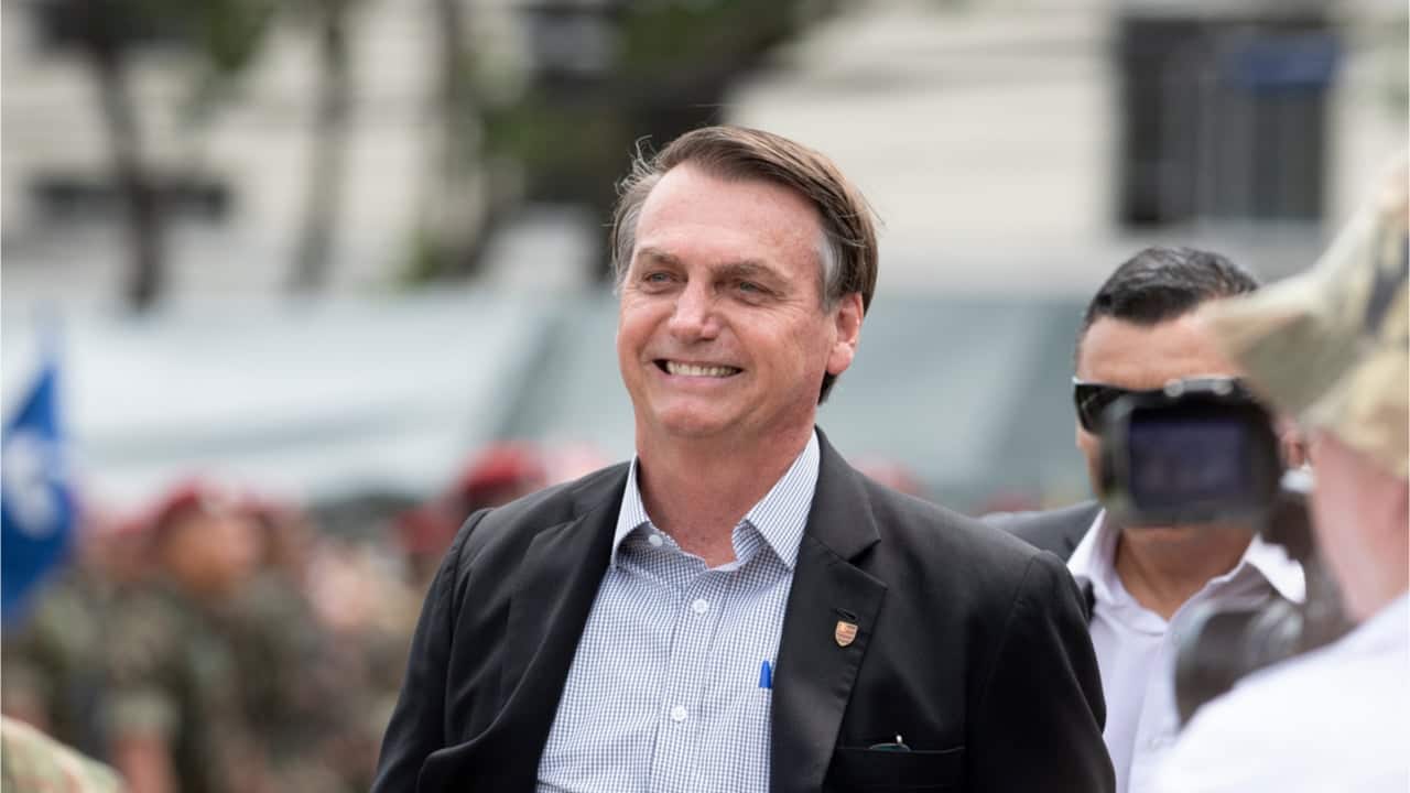 Jair Bolsonaro sorrindo em ambiente aberto