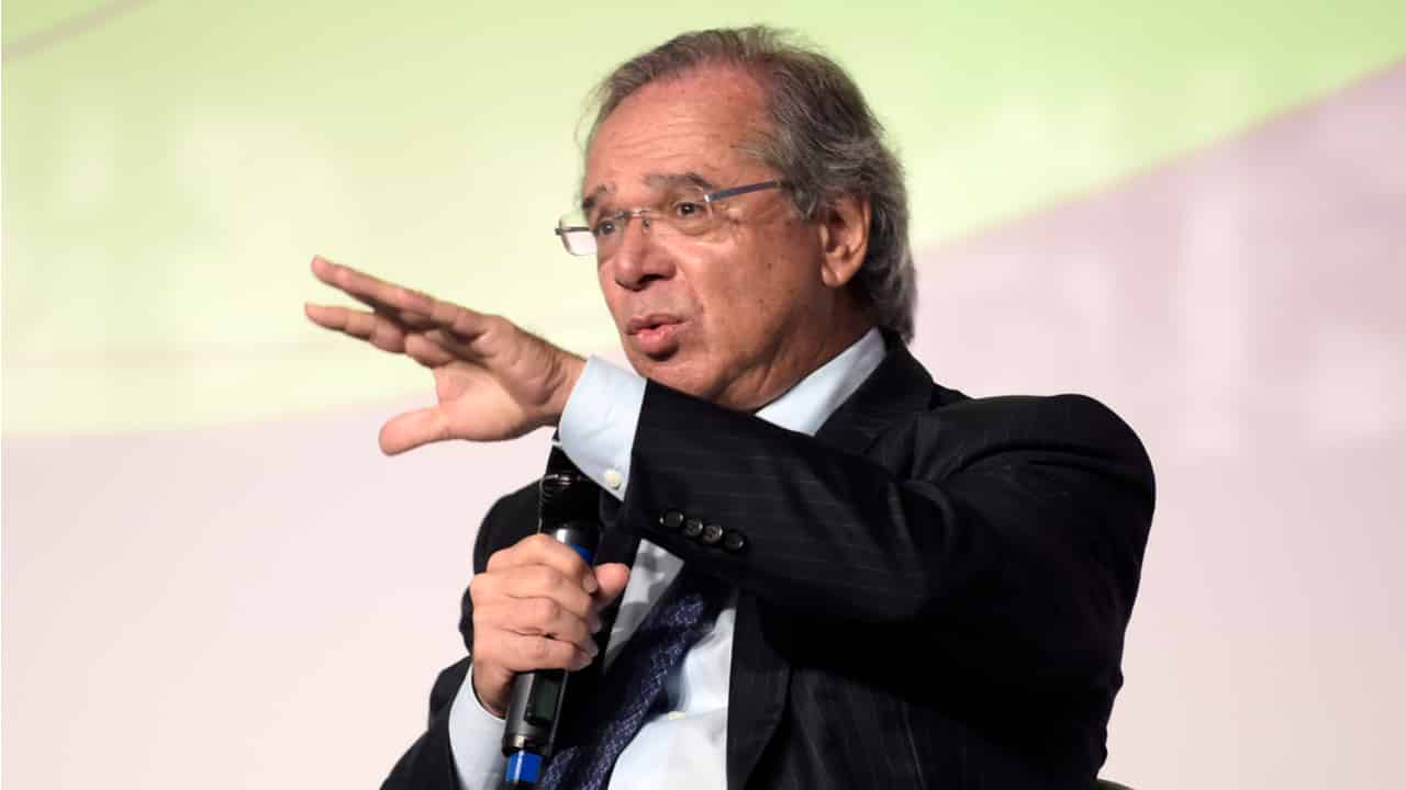 Paulo Guedes, ministro da Economia, com microfone em uma mão em discurso