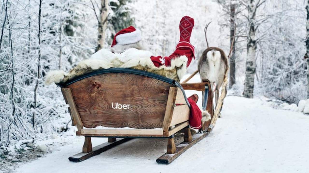 Foto de um Papai Noel sentado em trenó com a logo da Uber