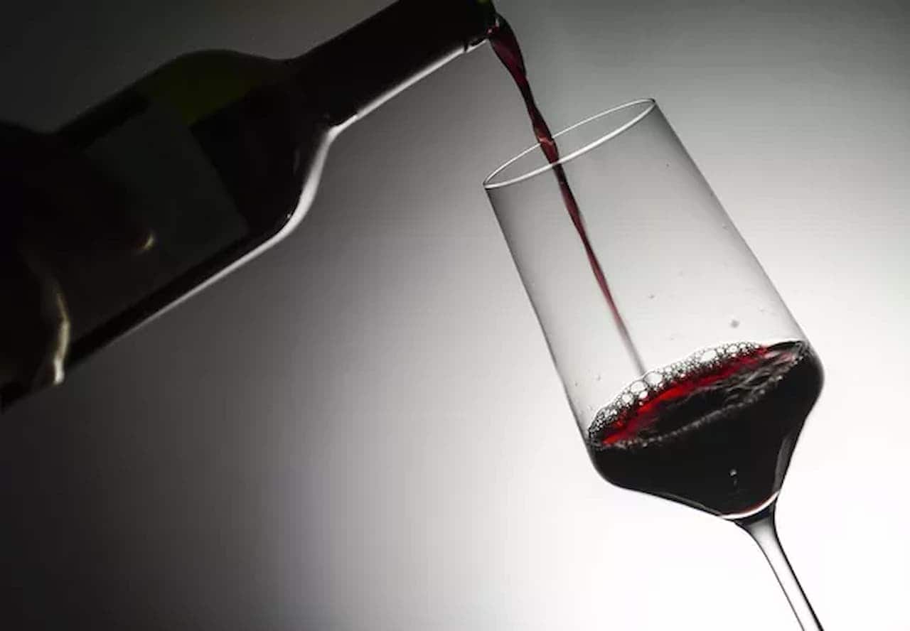 Garrafa de vinho servindo taça