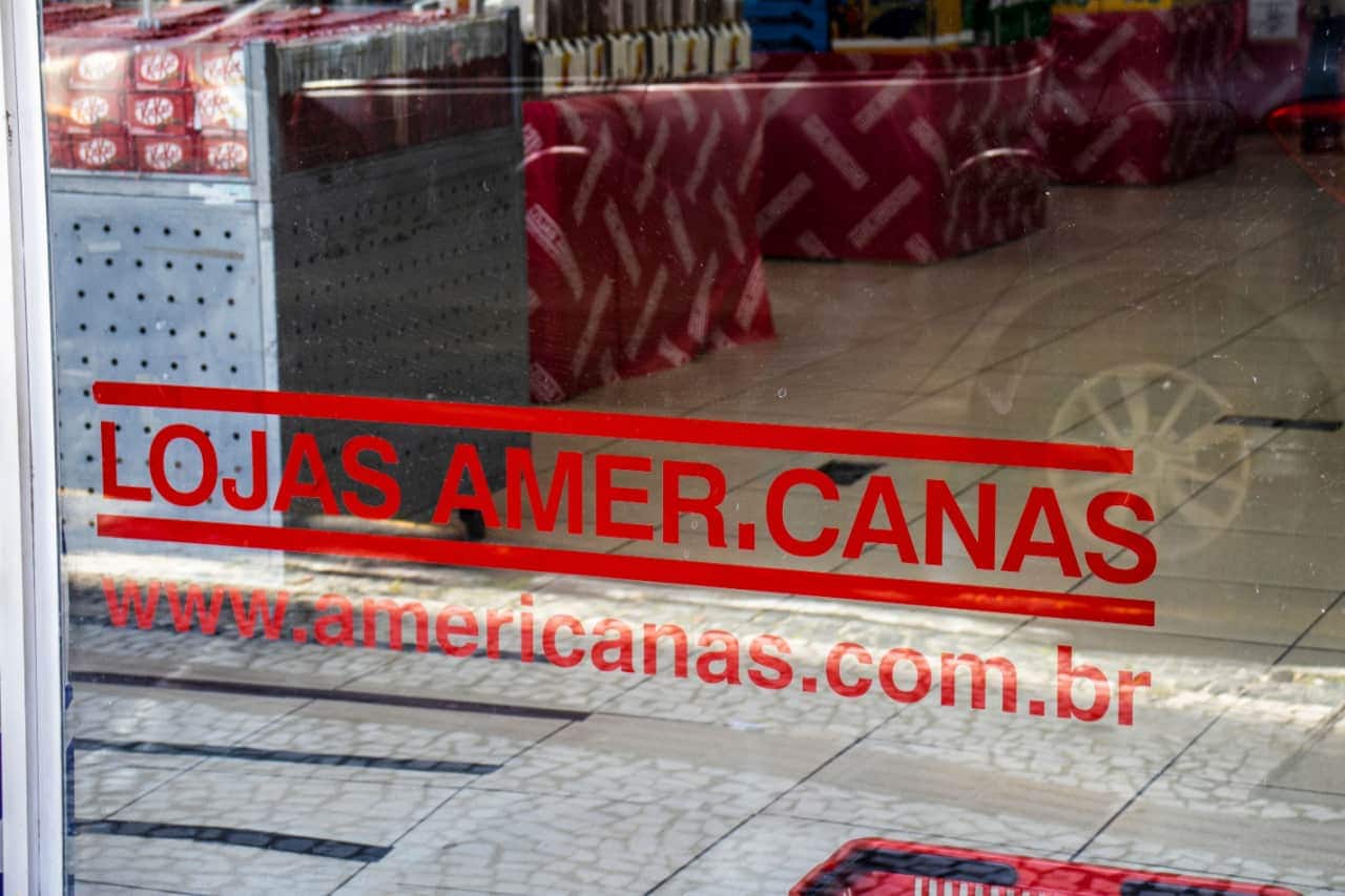 Vidraça com a logo das Lojas Americanas e endereço do site da empresa