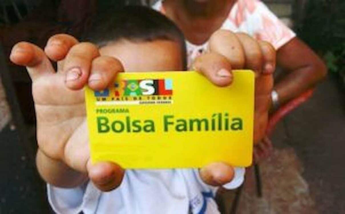 Criança segurando cartão do Bolsa Família