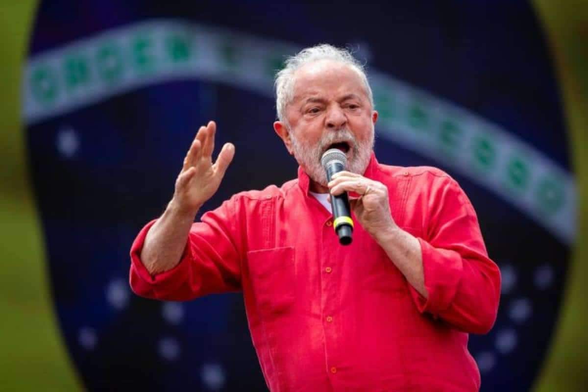 Lula fazendo discurso e bandeira do Brasil ao fundo