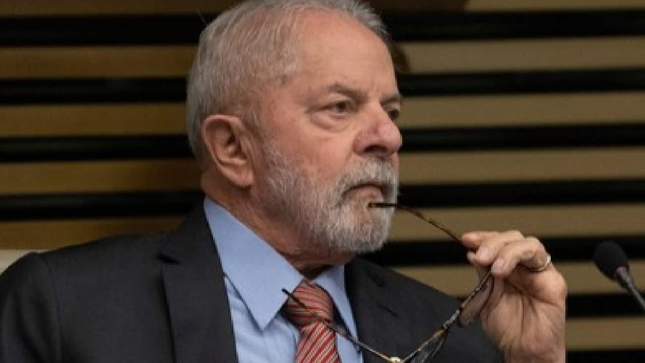 Presidente em debate, segurando seus óculos próximos ao rosto