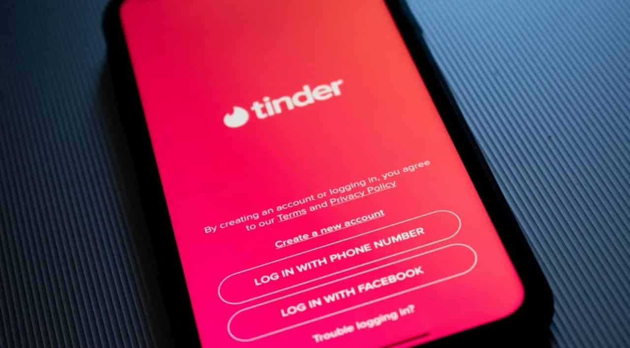 Imagem de celular com aplicativo do Tinder aberto na página de login