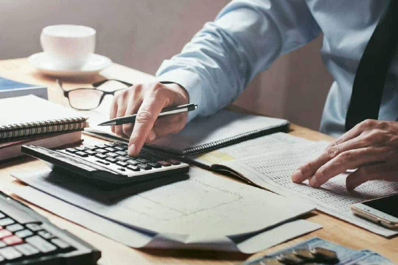 profissional fazendo contabilidade de empresa usando a calculadora